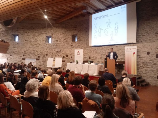 Florian Wallner am Rednerpult Workshop zu Mobbing im großen Festsaal der Burg Schlaining