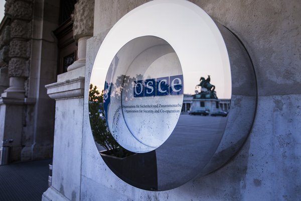 The OSCE logo next to the main gate outside of the Hofburg, Vienna.